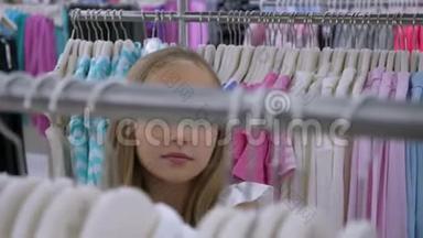 少女在时装店挑选服装。 时尚和购物概念